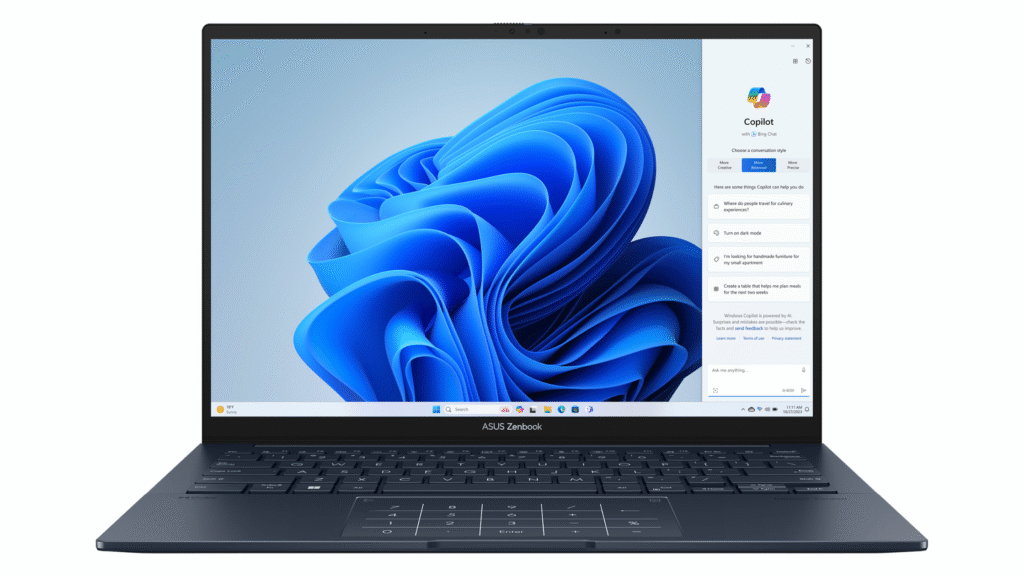A dark blue Asus Zenbook laptop displaying the Windows 11 desktop with the vibrant blue swirl wallpaper and the Copilot AI assistant panel open on the right side of the screen.