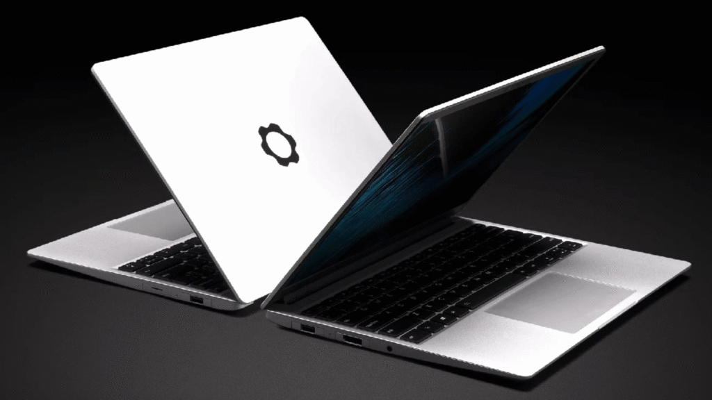 Two silver laptops, likely running Linux, are angled in a product shot on a dark background; one shows its white lid featuring a black stylized logo (resembling the Ubuntu icon), and the other shows its keyboard and screen.